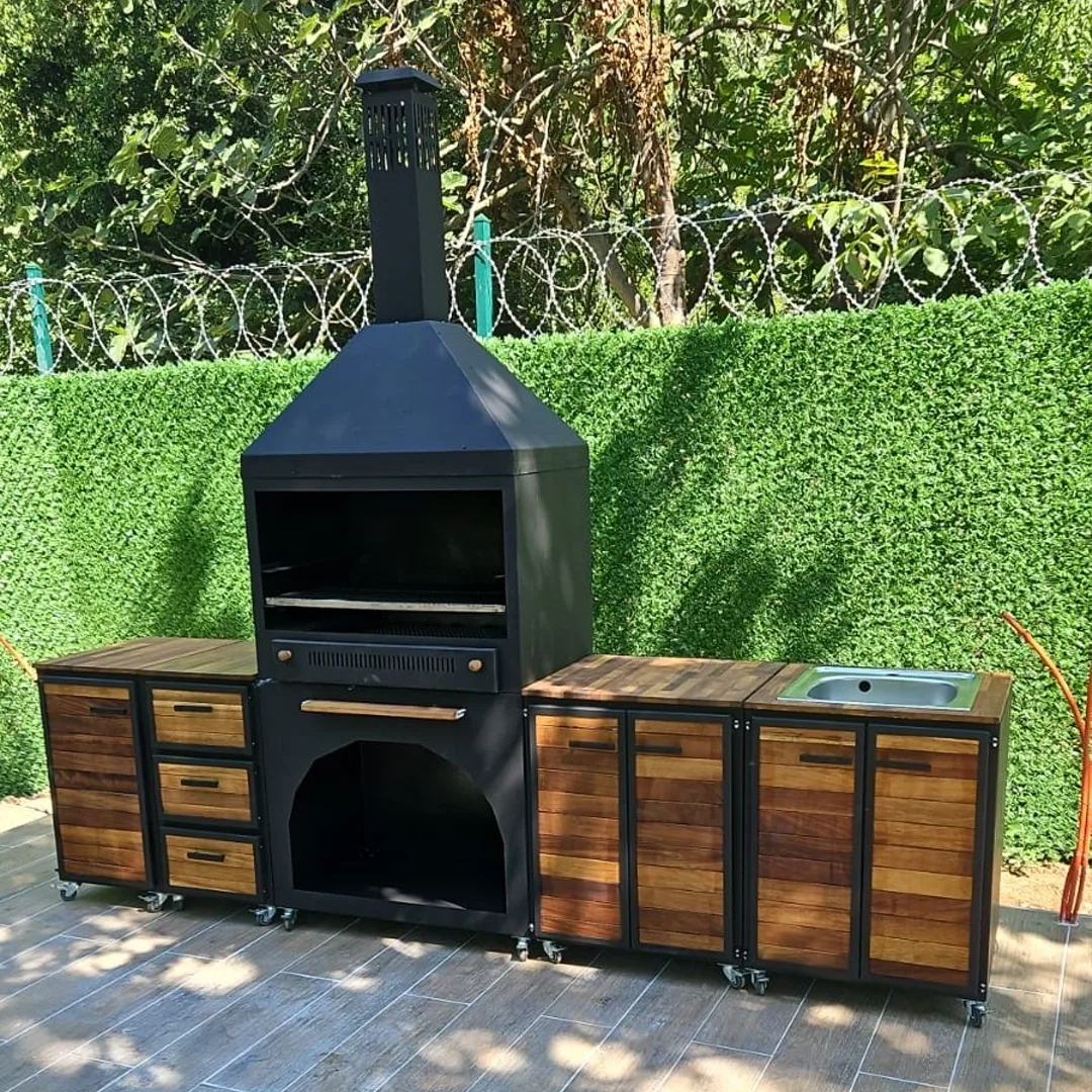 Taş zeminli bahçede tezgahlı barbekü, oturma alanı ve ateş çukuru